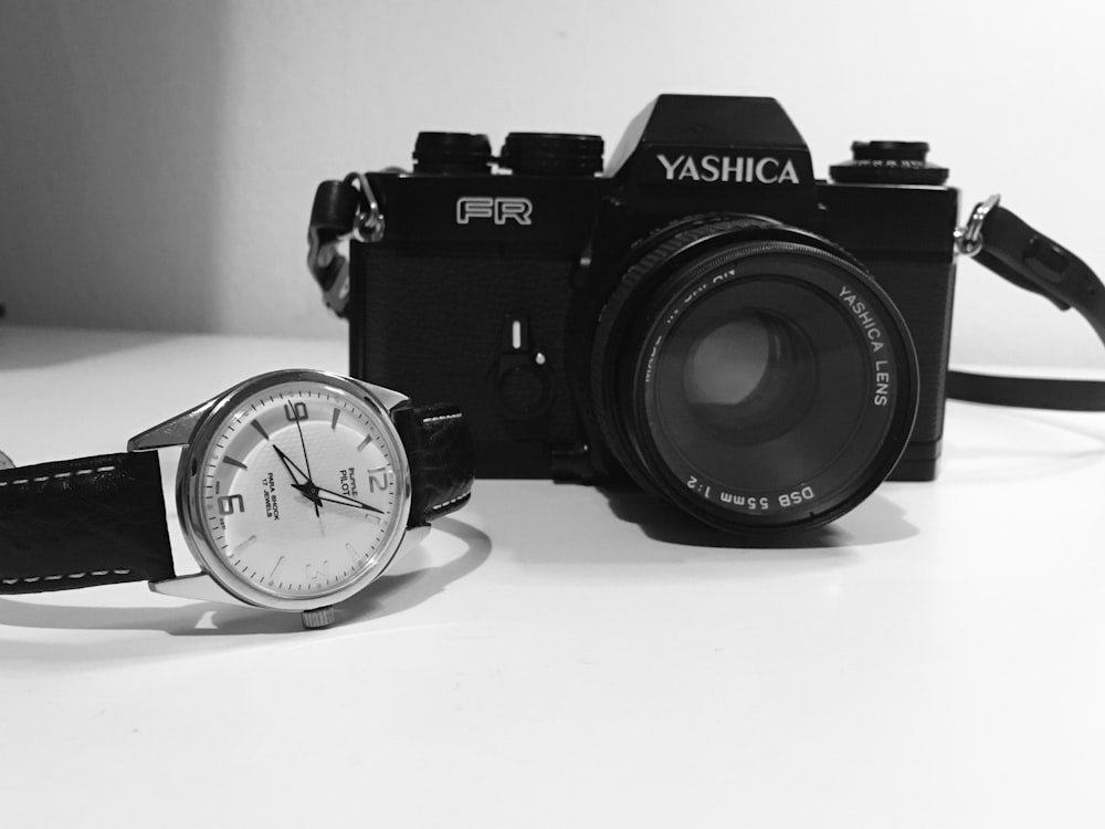 a black and white photo of a watch and a camera