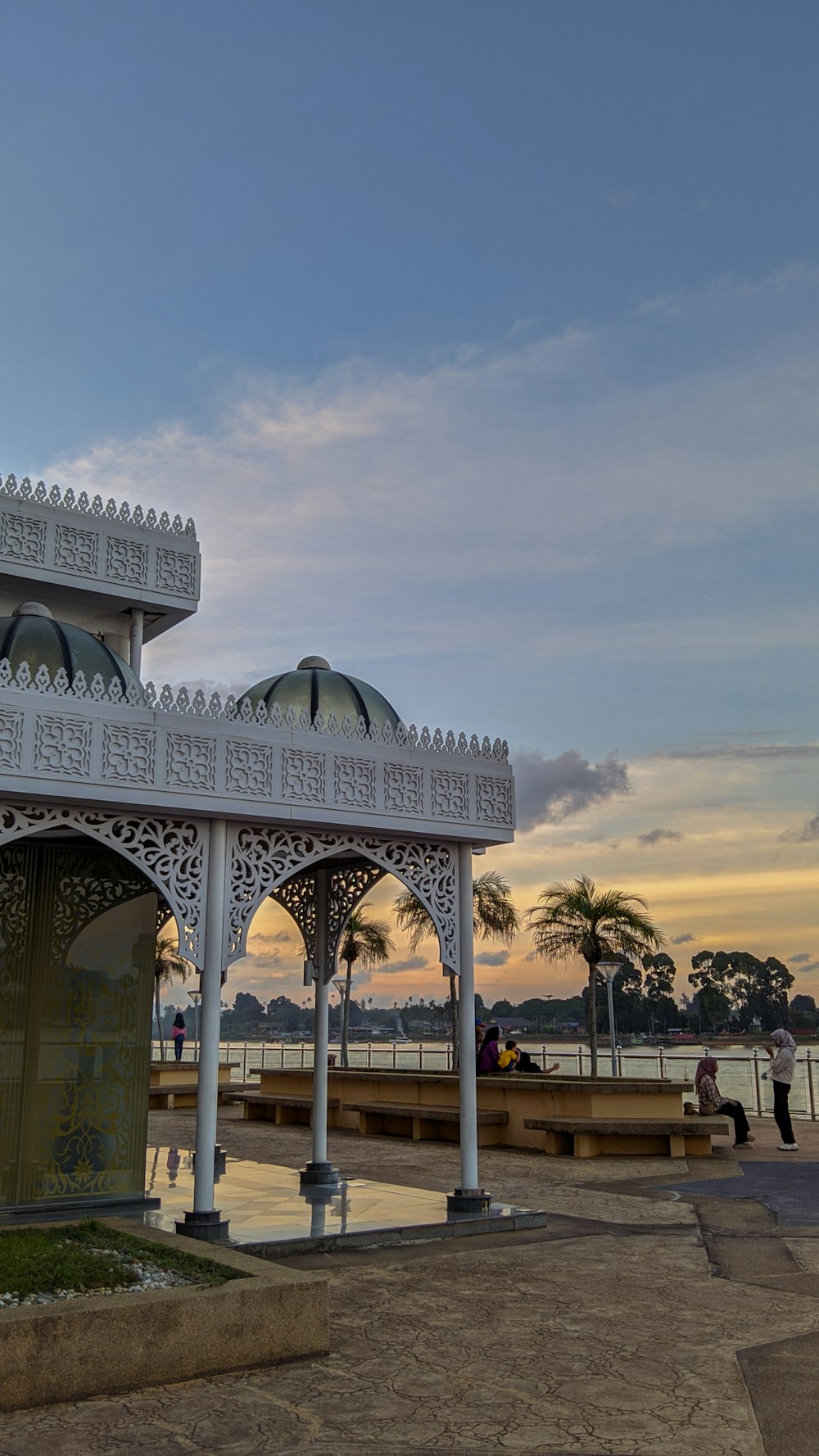 a white gazebo sitting next to a body of water