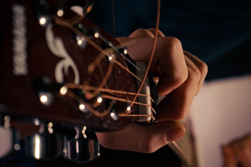a person playing a guitar with strings attached to it