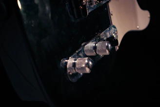 Close-up of a sleek 3D-printed guitar accessory in matte black with subtle orange highlights.