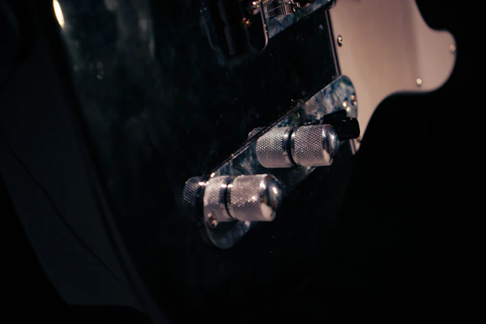 Close-up of a sleek 3D-printed guitar accessory in matte black with subtle orange highlights.