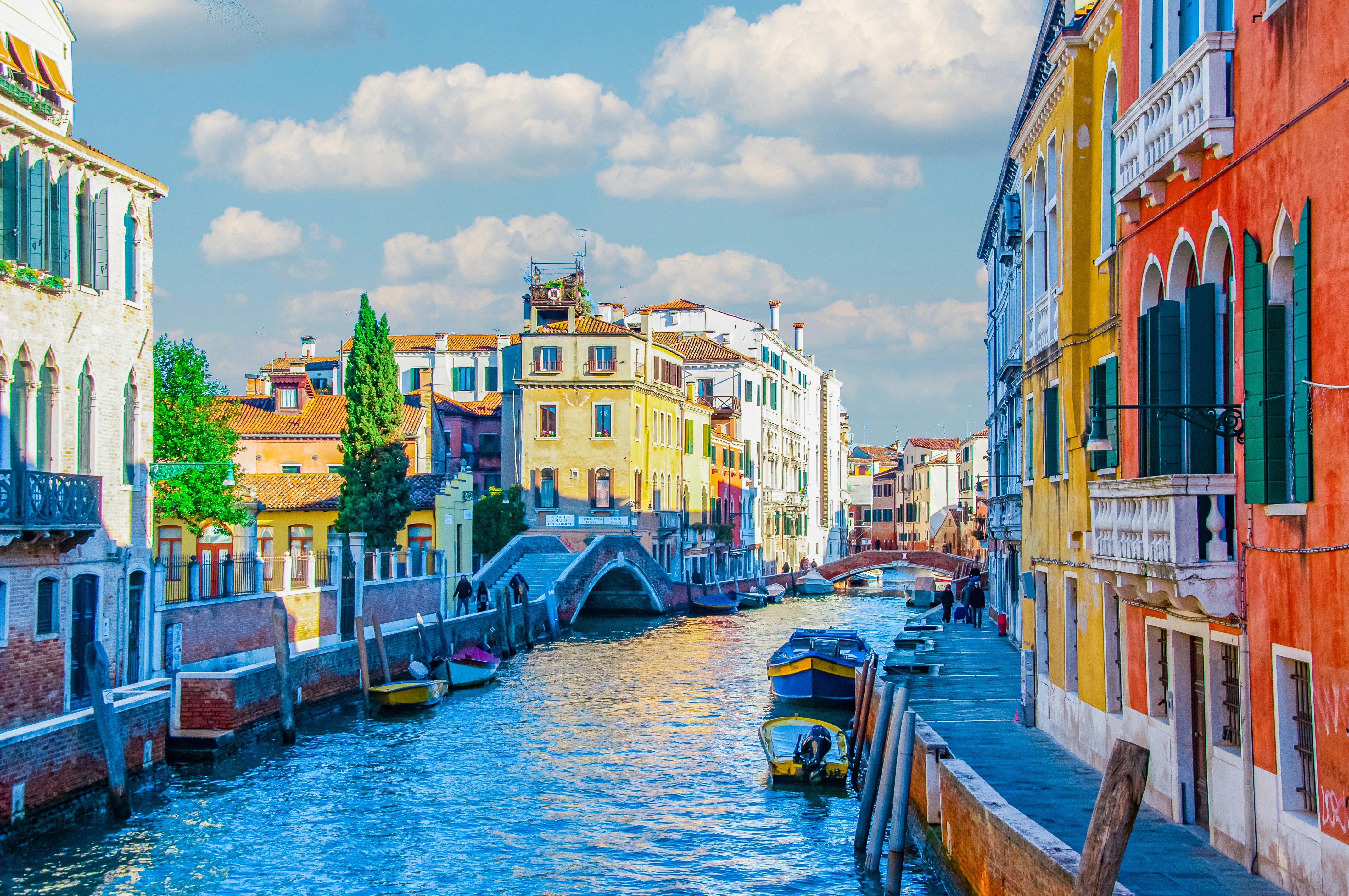a river running through a city next to tall buildings, Boats in Venice canal, colorful houses near Venice Canal, Canal view of Venice Italy