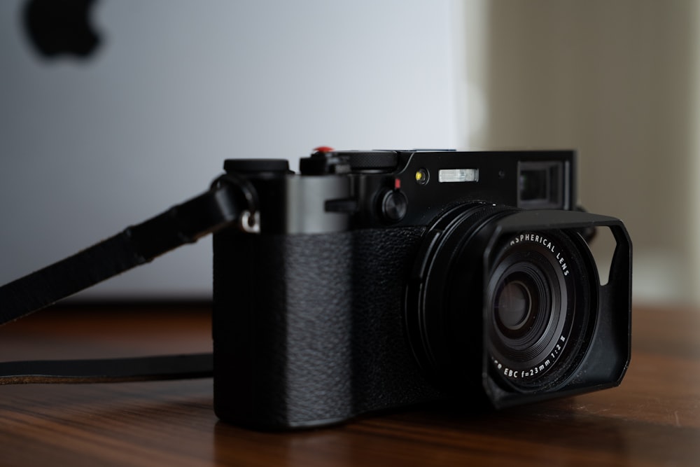 a black camera sitting on top of a wooden table