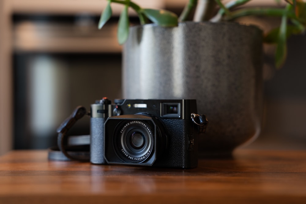 a camera sitting on a table next to a potted plant