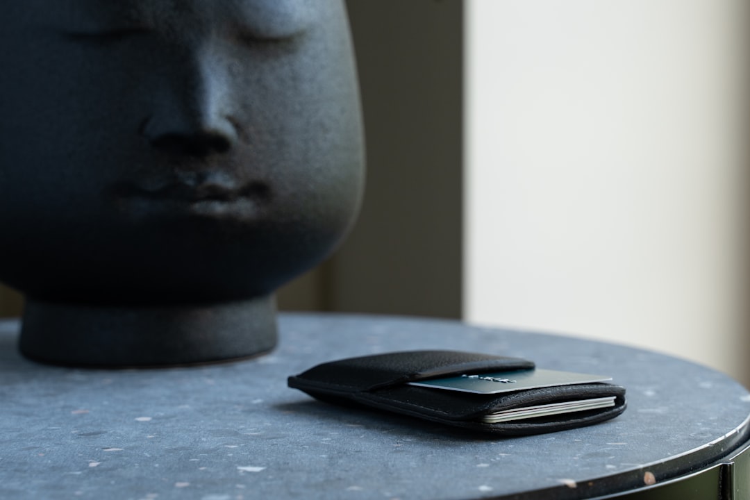 a cell phone sitting on top of a table, Black card holder wallet. Minimalistic card holder wallet design. Small card hol