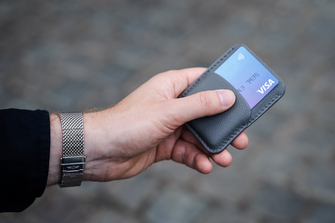 Photo of a gray leather card holder wallet in hands.