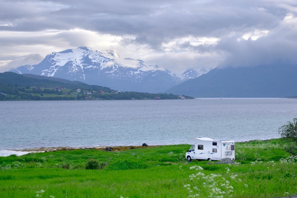 a truck parked on the side of a road next to a body of water