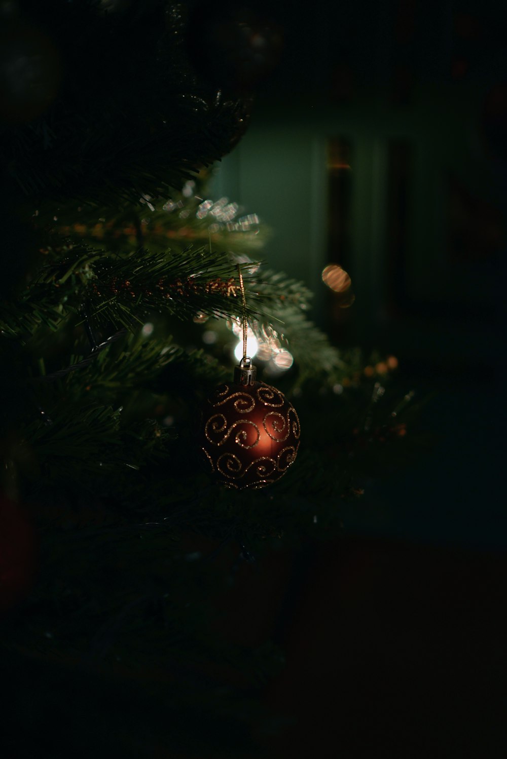 a christmas tree with a red ornament hanging from it