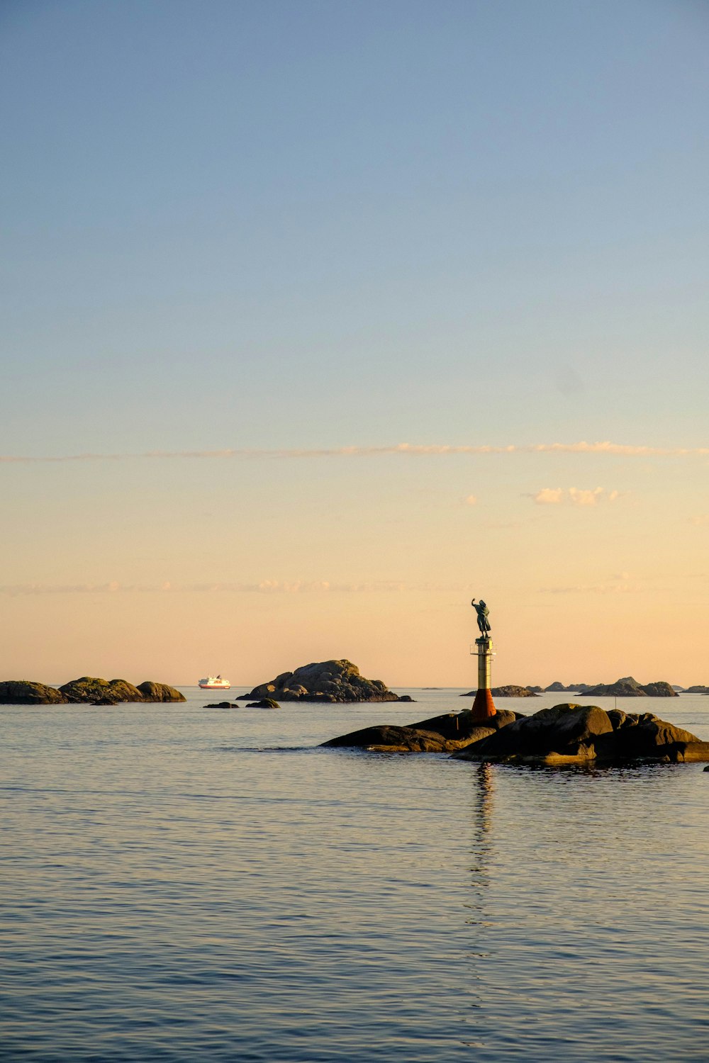 a lighthouse on a small island in the middle of the ocean