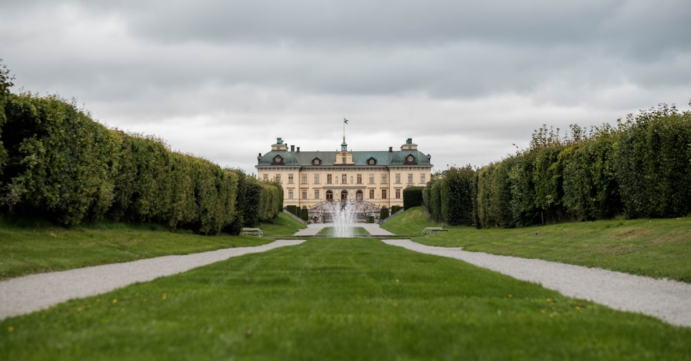 a large building sitting in the middle of a lush green field