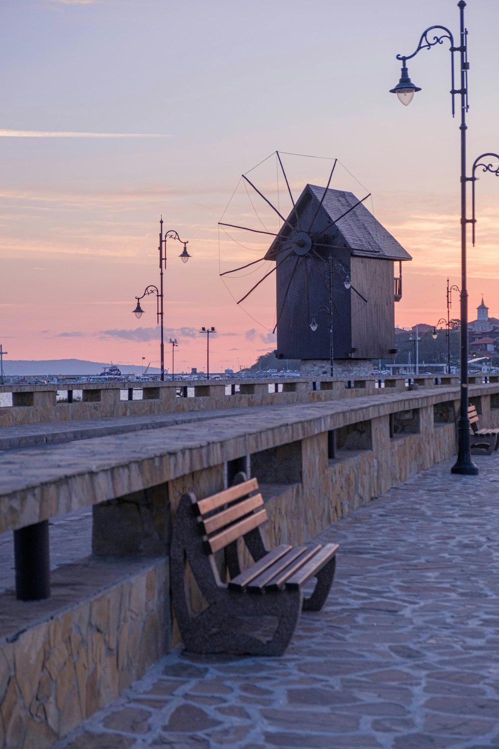 un banc en bois posé sur une passerelle en pierre