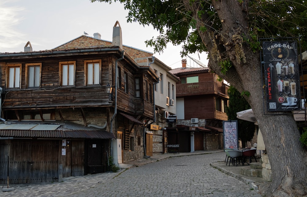 a cobblestone street lined with wooden buildings