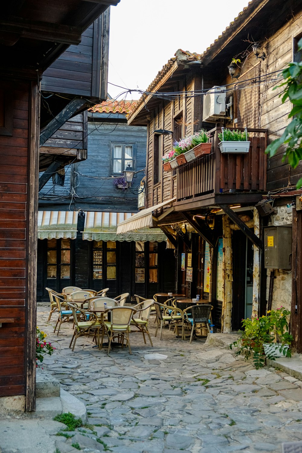 a cobblestone street lined with tables and chairs