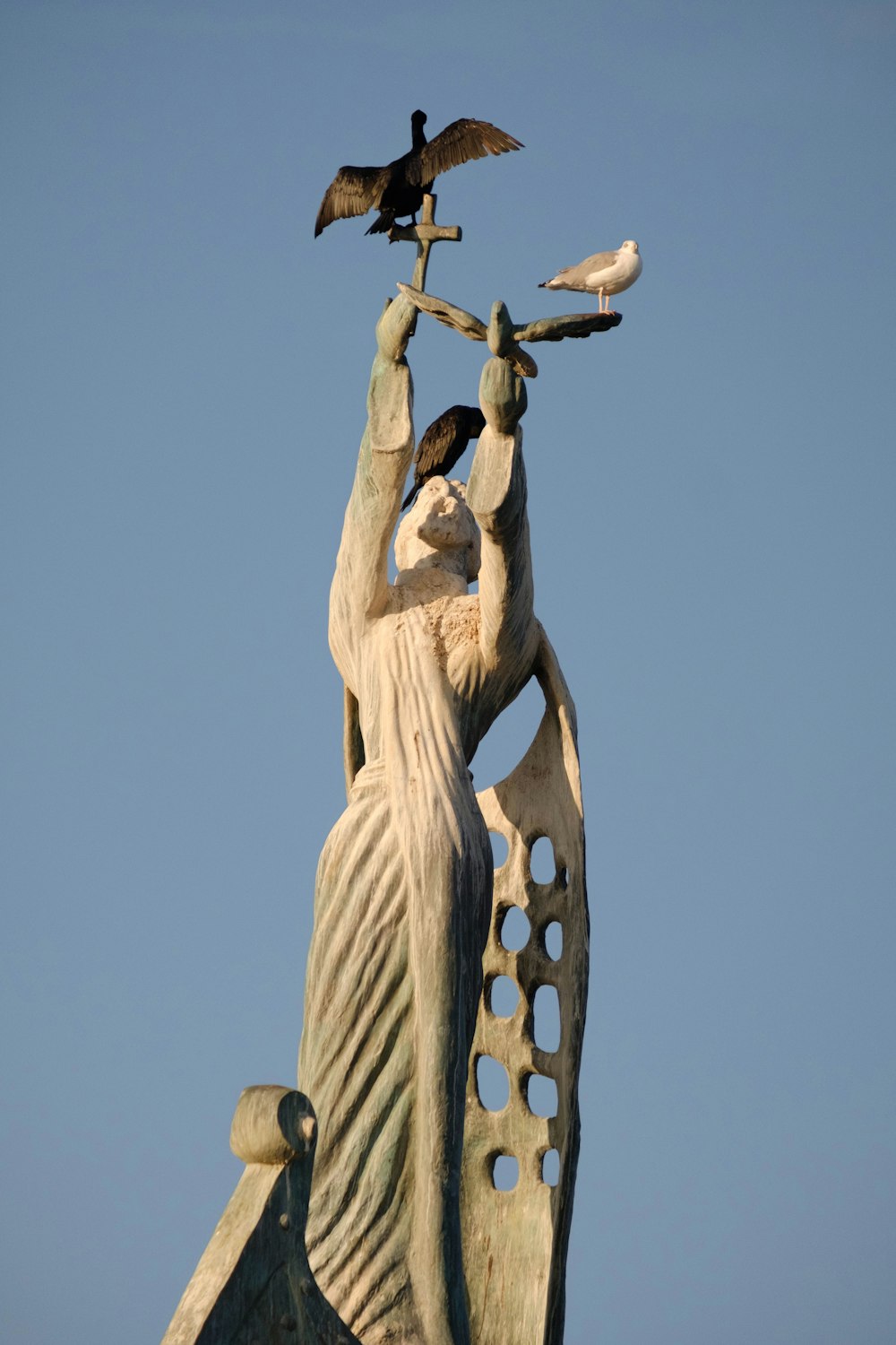 une statue d’une femme tenant un oiseau sur son bras