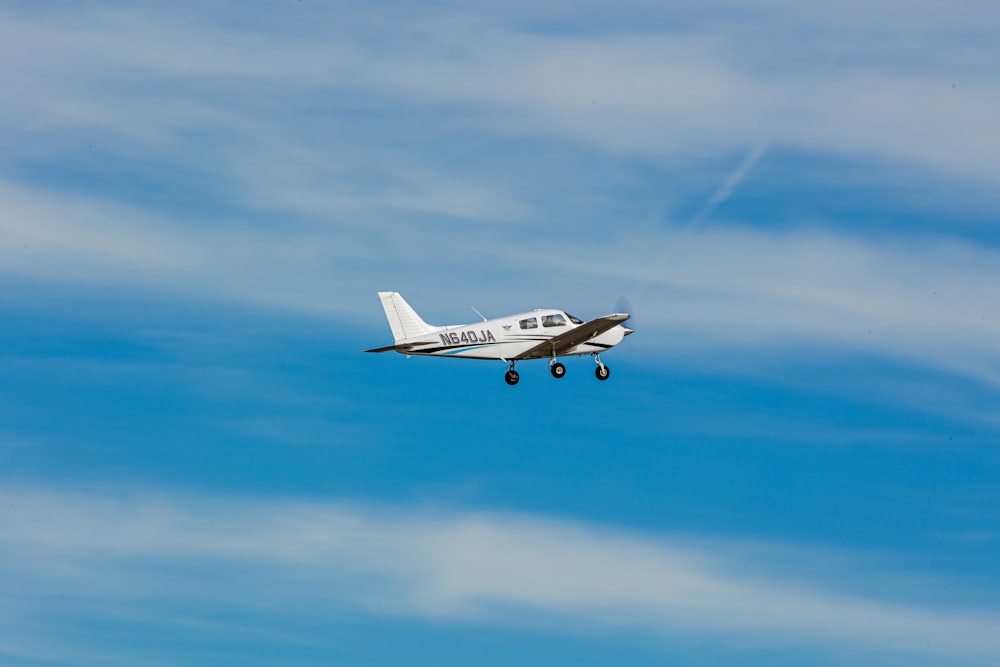 a small airplane flying through a blue sky