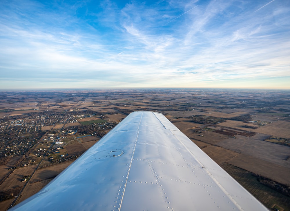 the wing of an airplane flying over a rural area
