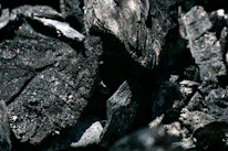 Close-up of premium biochar material with subtle green lighting highlighting texture.