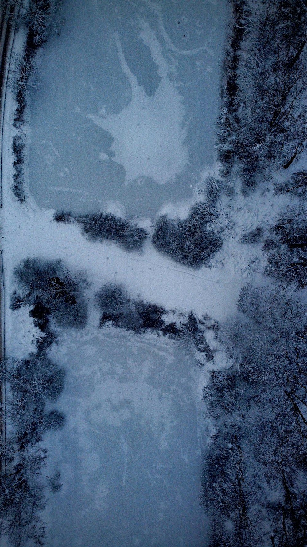 an aerial view of snow covered trees and a river