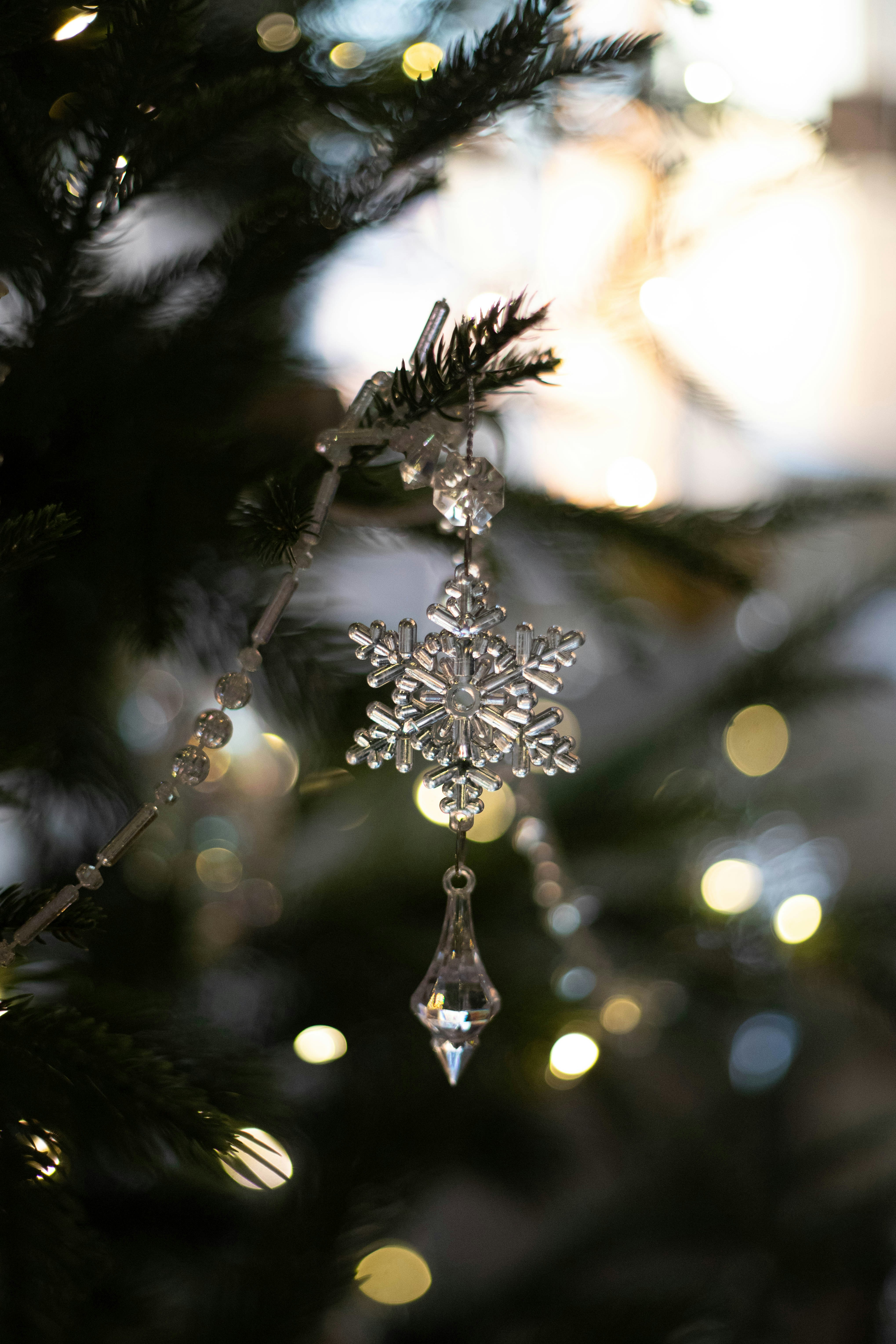 a snowflake ornament hanging from a christmas tree