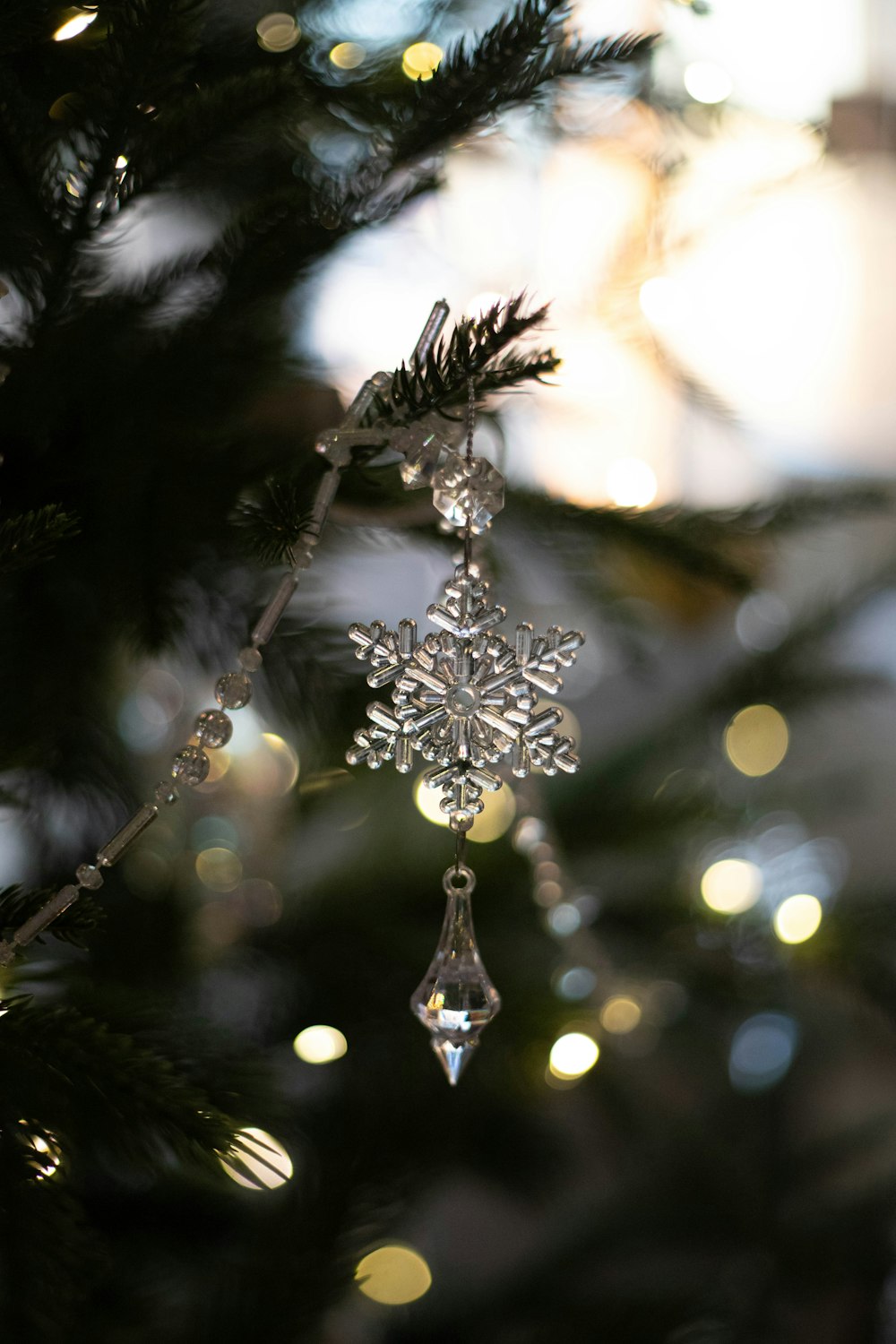 a snowflake ornament hanging from a christmas tree