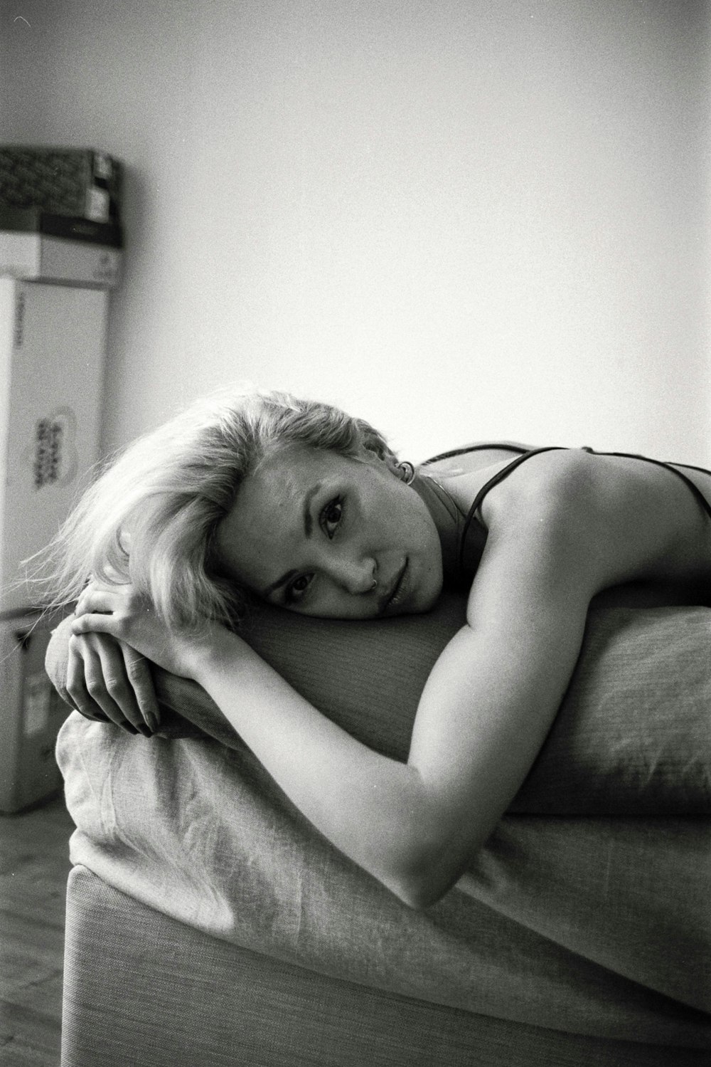 a black and white photo of a woman laying on a bed