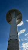 Steel water tower structure standing tall against a clear blue sky in a rural construction site.
