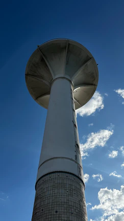 Steel water tower structure standing tall against a clear blue sky in a rural construction site.