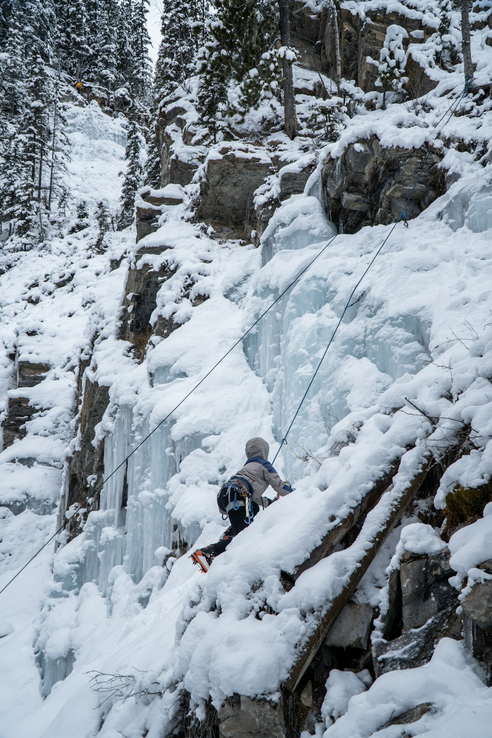 a man is climbing up a snowy mountain