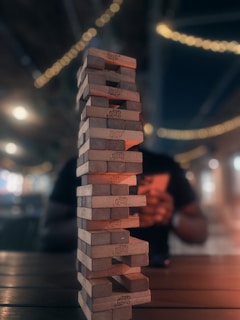 A completed tower-style building block structure standing tall on a wooden table.