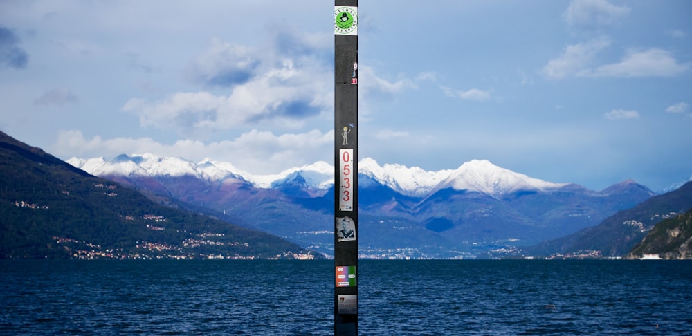 a ski pole sticking out of the water with mountains in the background