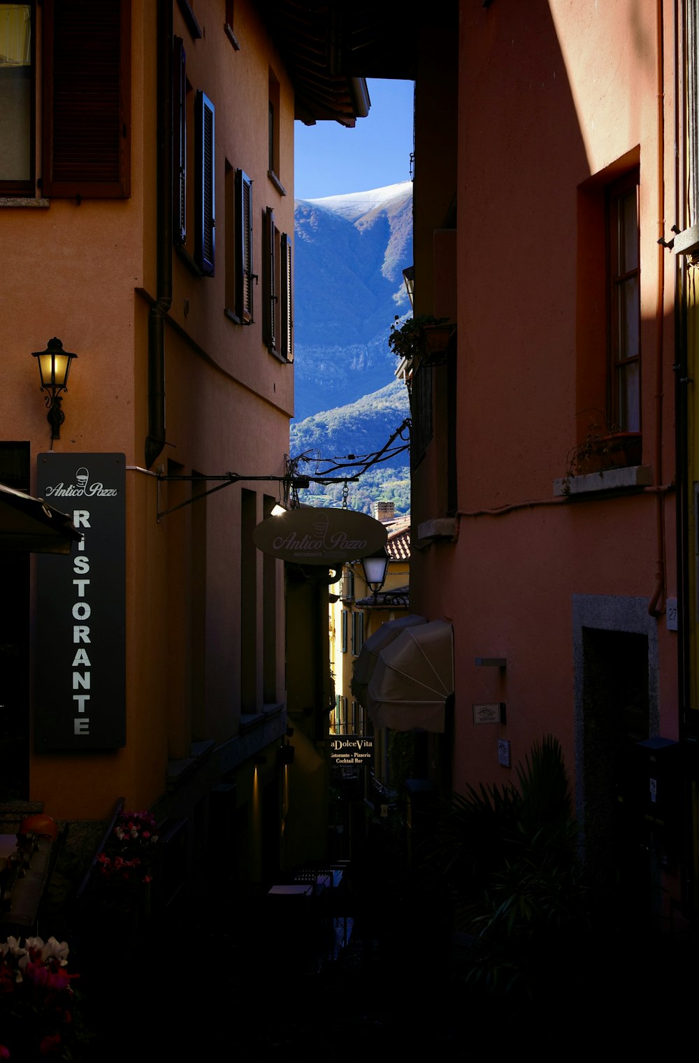 a narrow alley way with a mountain in the background