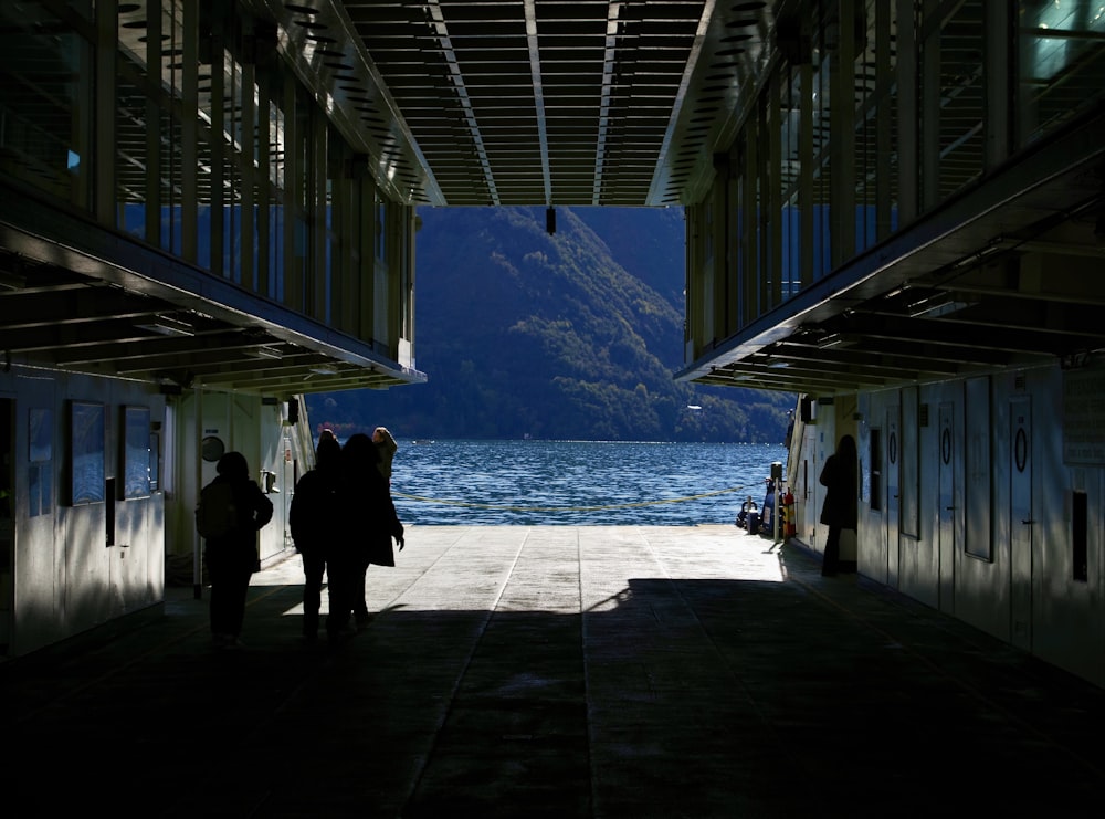 a group of people standing under a bridge next to a body of water