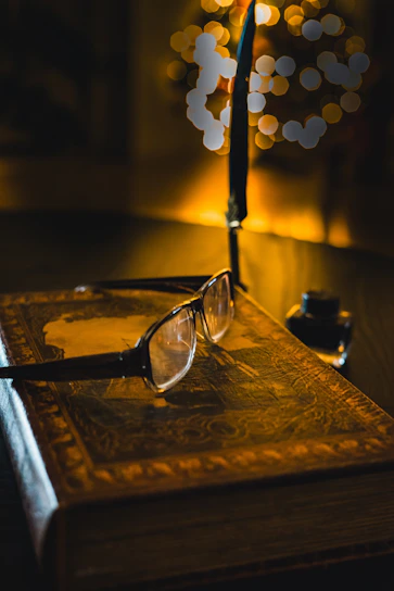 Cozy reading nook with vintage books and a quill pen resting on an open ancient manuscript.
