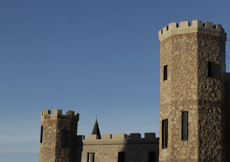 The imposing silhouette of Castillo de Atienza against a clear blue sky.