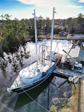 A technician performing maintenance on a sleek leisure boat docked by the water.