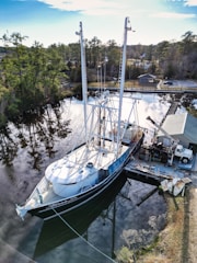 Boat docked at marina with technicians performing maintenance.