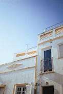 A freshly painted luxury home's exterior with crisp white walls and gold trim under bright sunlight.