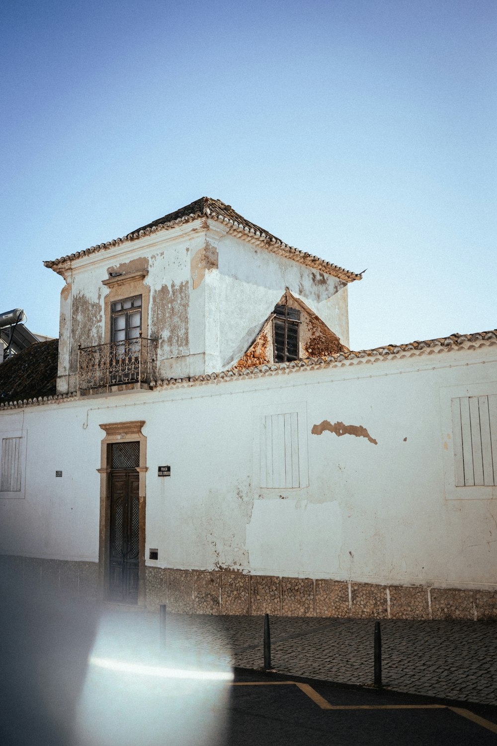 a white building with shutters on the windows