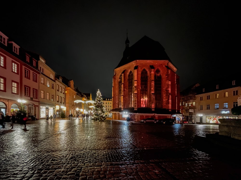 Uma rua da cidade à noite com uma árvore de Natal iluminada