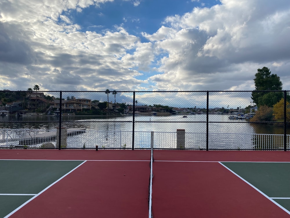 una cancha de tenis junto a un cuerpo de agua