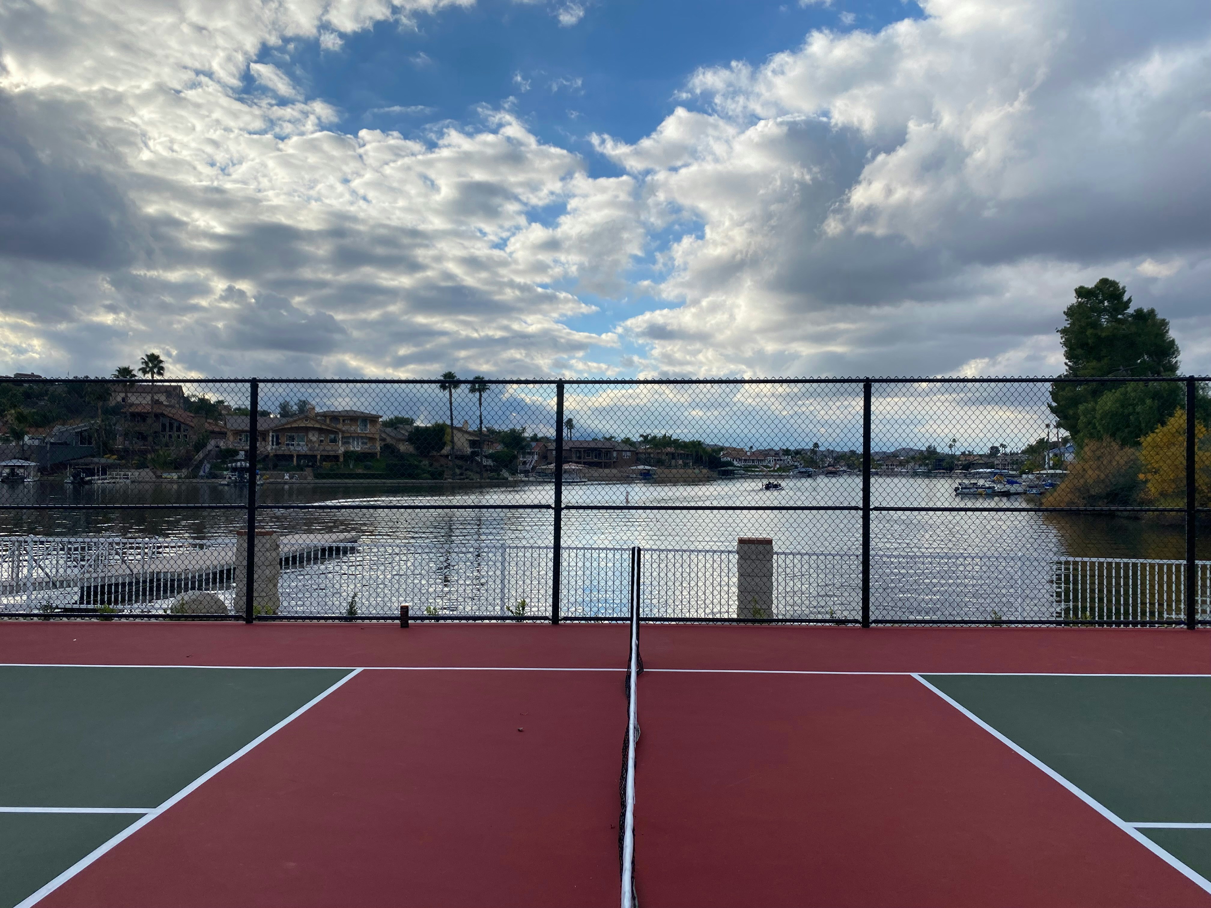 a tennis court next to a body of water