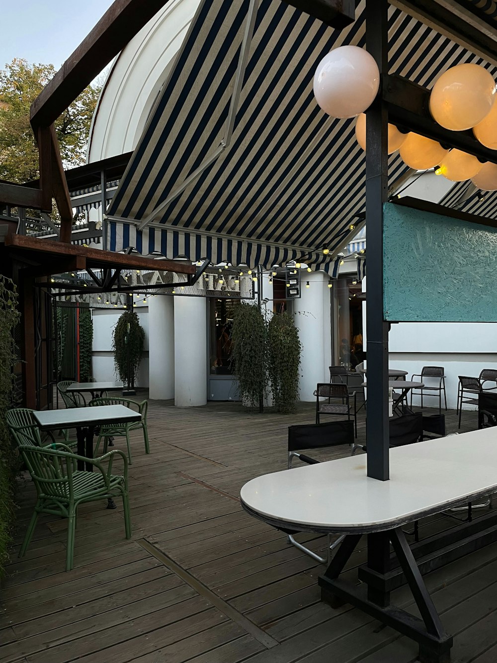 a patio with tables and chairs under an awning