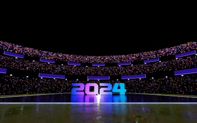 A futuristic stadium illuminated with vibrant lights displays the numbers 2024 prominently at its center. The stadium is filled with colorful lights and reflective surfaces, creating a dynamic and festive atmosphere.