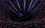 A digital art piece with the numbers '2024' illuminated on a platform at the center. Surrounding the platform, a vast array of multicolored stars and sparkles create a galaxy-like effect. Beams of light shine downwards, enhancing the futuristic and celebratory atmosphere.