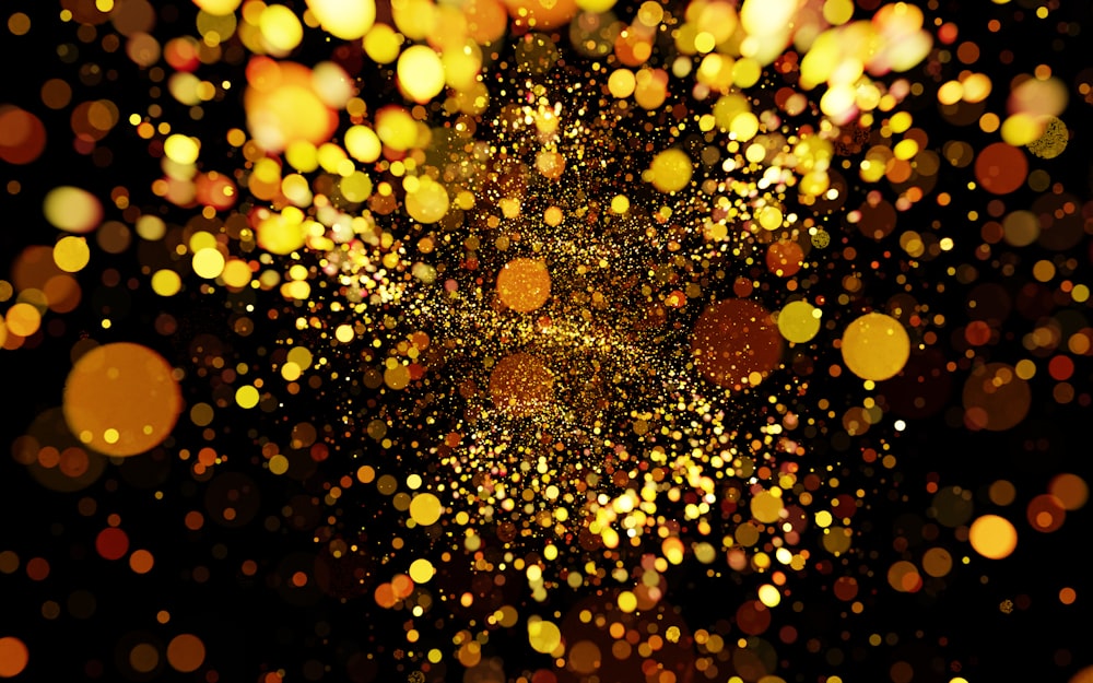 a blurry image of gold glitter on a black background