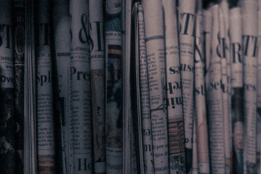 a row of newspapers sitting on top of a shelf