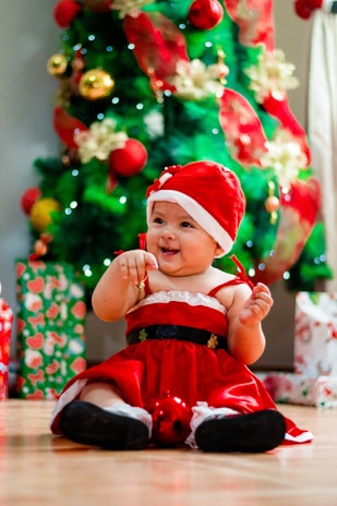 A newborn baby dressed in a festive Christmas outfit.