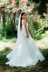 A bride gracefully walking through a blooming garden, veil flowing behind her.