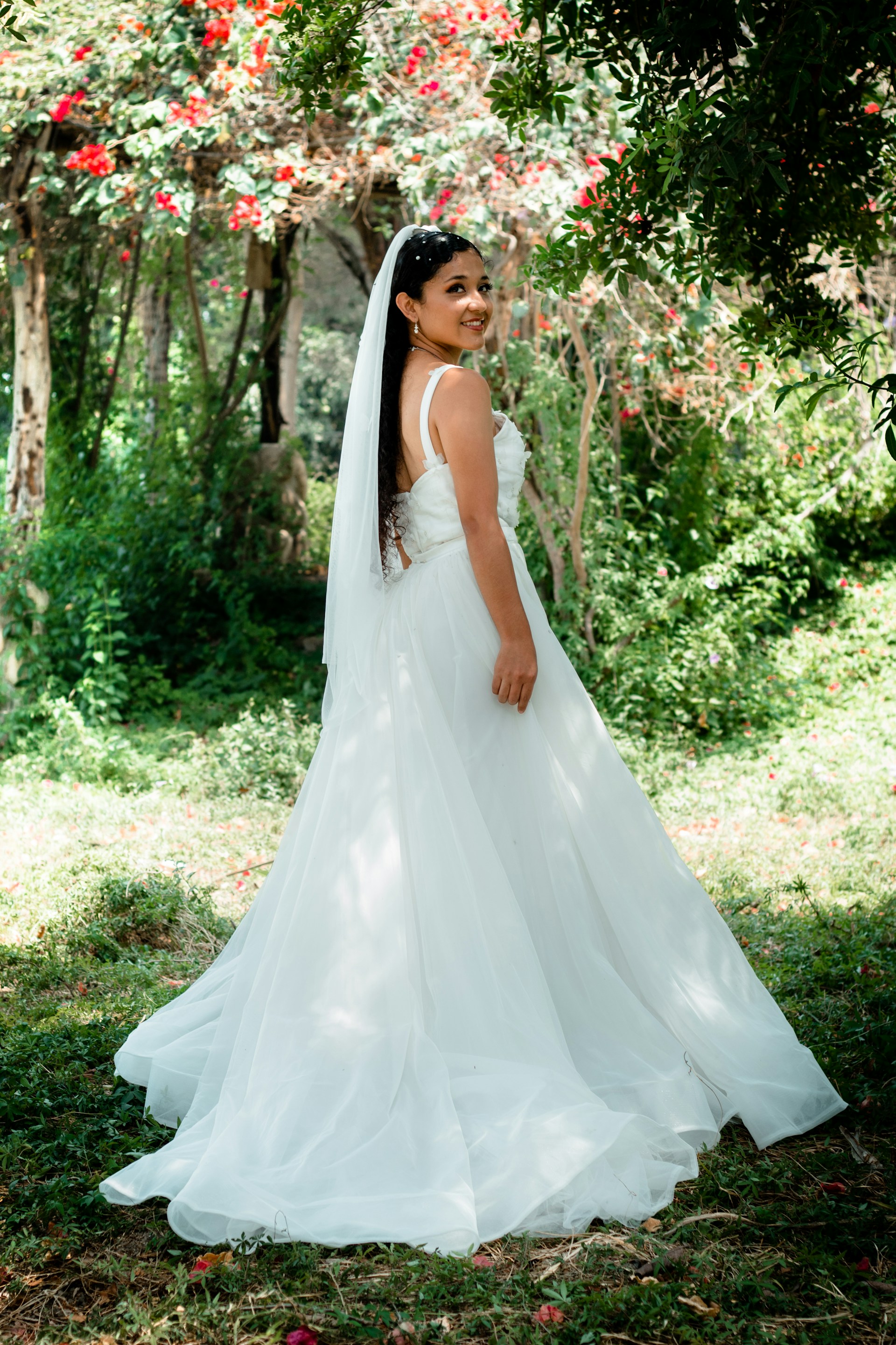 A radiant bride laughing joyfully in a sunlit garden, capturing the magic of a wedding day.