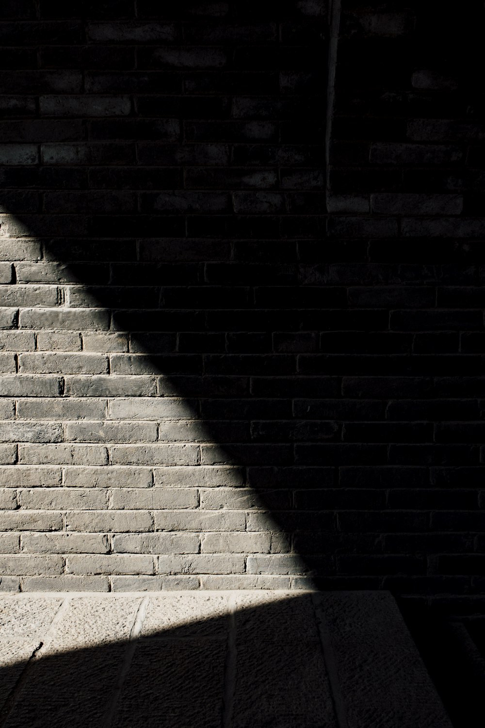 a brick wall with a shadow of a person on it